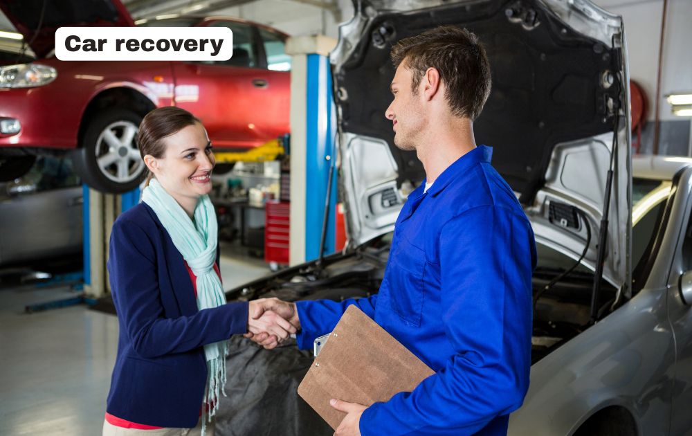 Professional car recovery flatbed tow truck transporting a broken down vehicle safely on a UK road