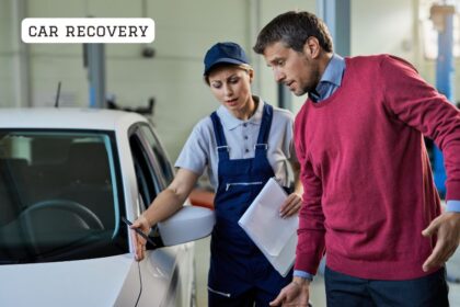 Professional car recovery flatbed tow truck transporting a broken down vehicle safely on a UK road