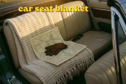 Newborn baby wrapped in a car seat blanket resting safely inside a rear facing car seat