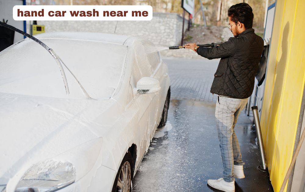 Professional hand car wash detailing a vehicle exterior with soapy foam.