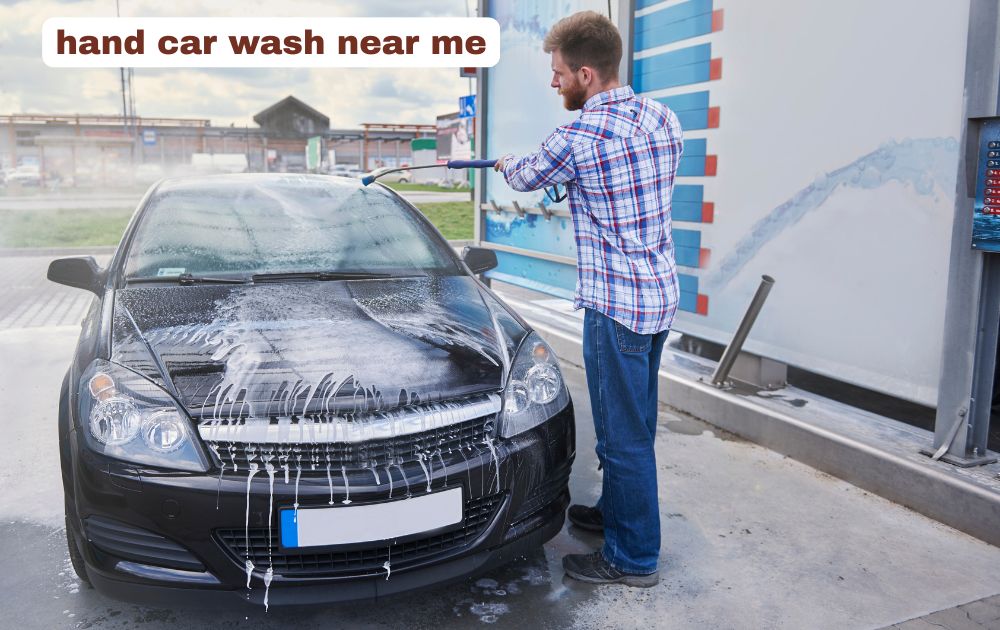 Professional hand car wash detailing a vehicle exterior with soapy foam.