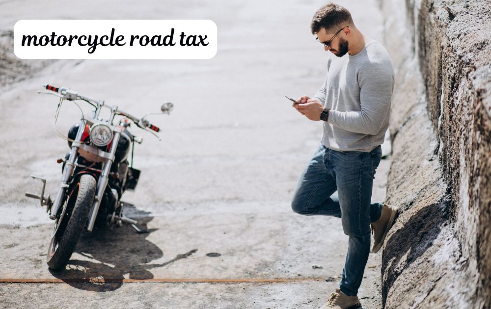 Rider checking motorcycle road tax papers V5C logbook and MOT certificate beside a parked motorbike